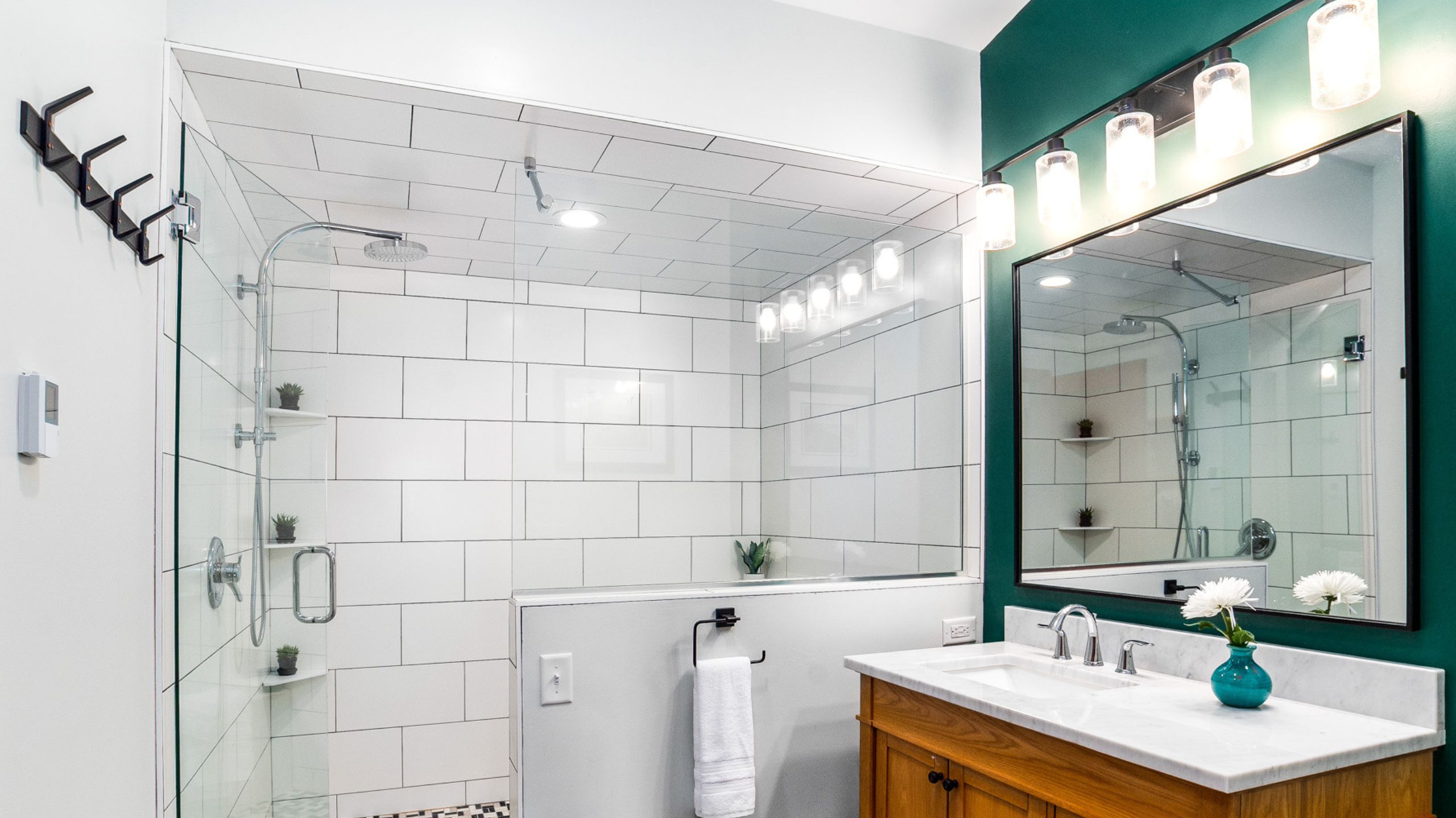 tub shower combo with a bathroom vanity and lighting