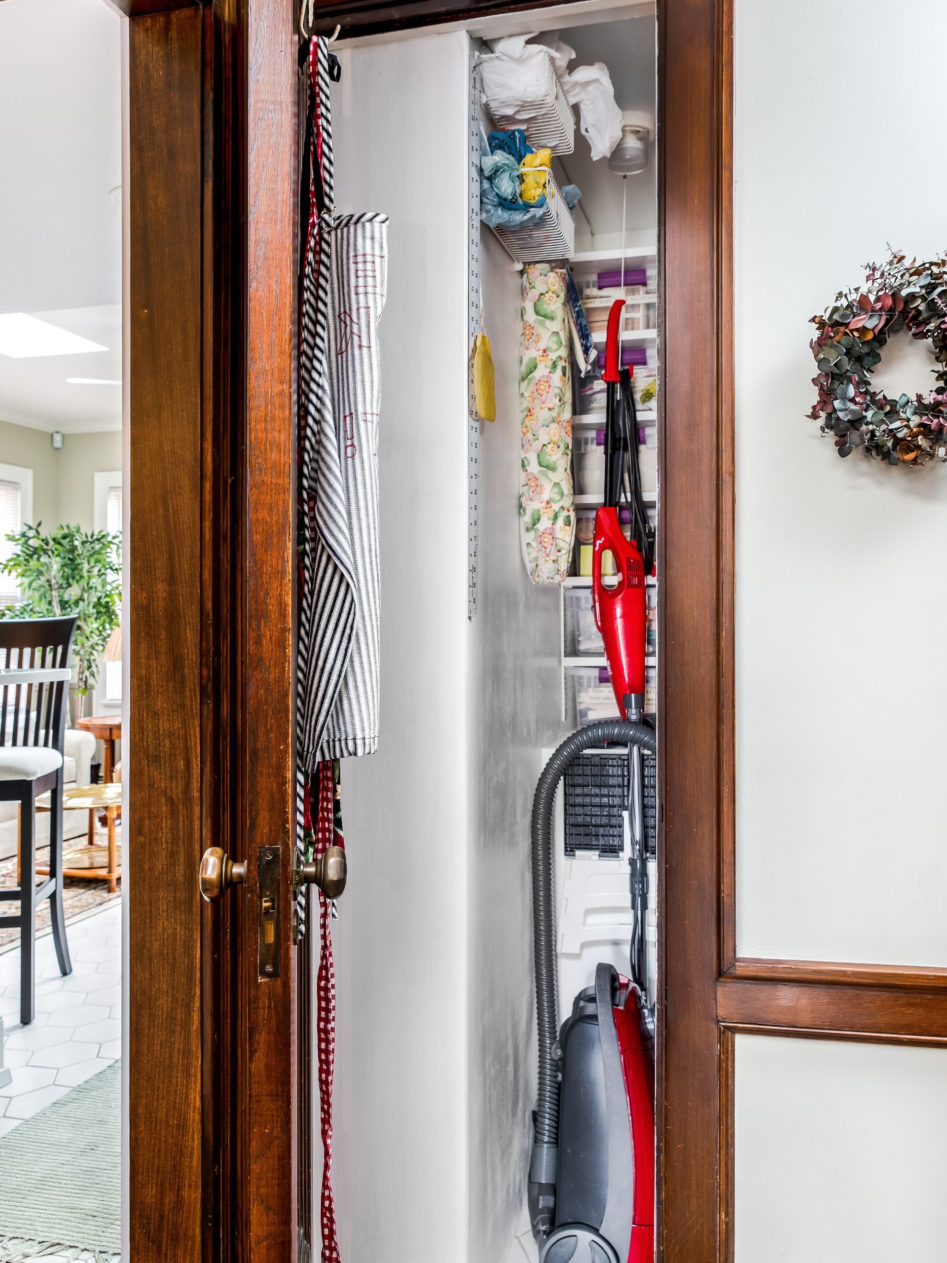 small closet with half of the space showing vertical storage for smaller items and vacuum 