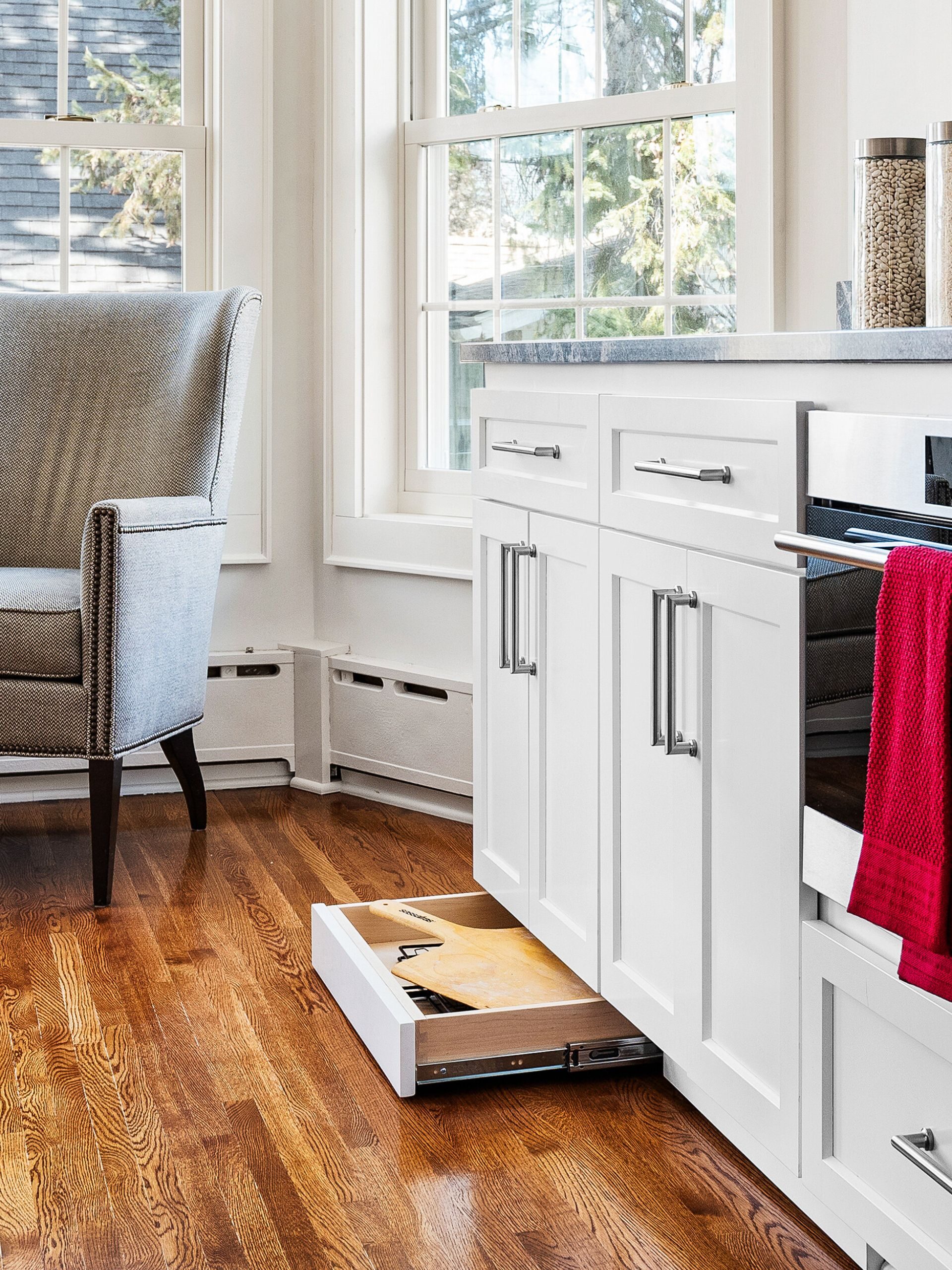custom storage solutions include these white cabinets with toe kick storage opened