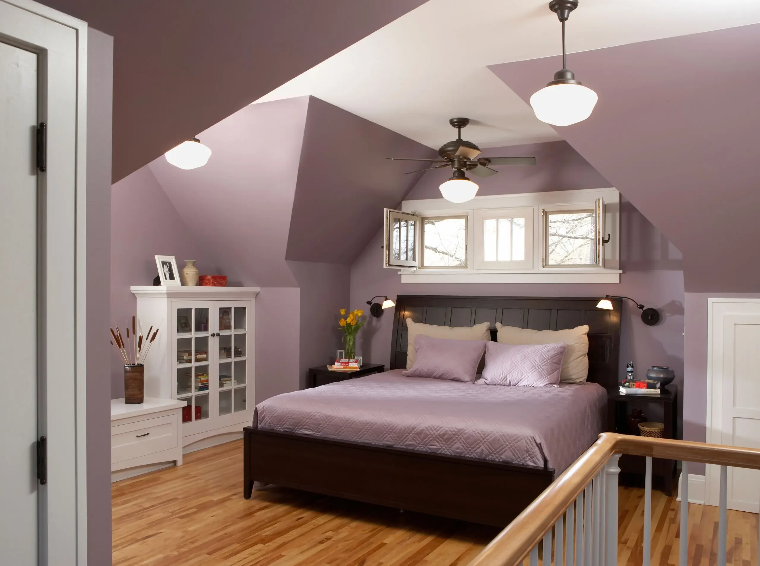 attic bedroom with soft purple walls with a row of windows above